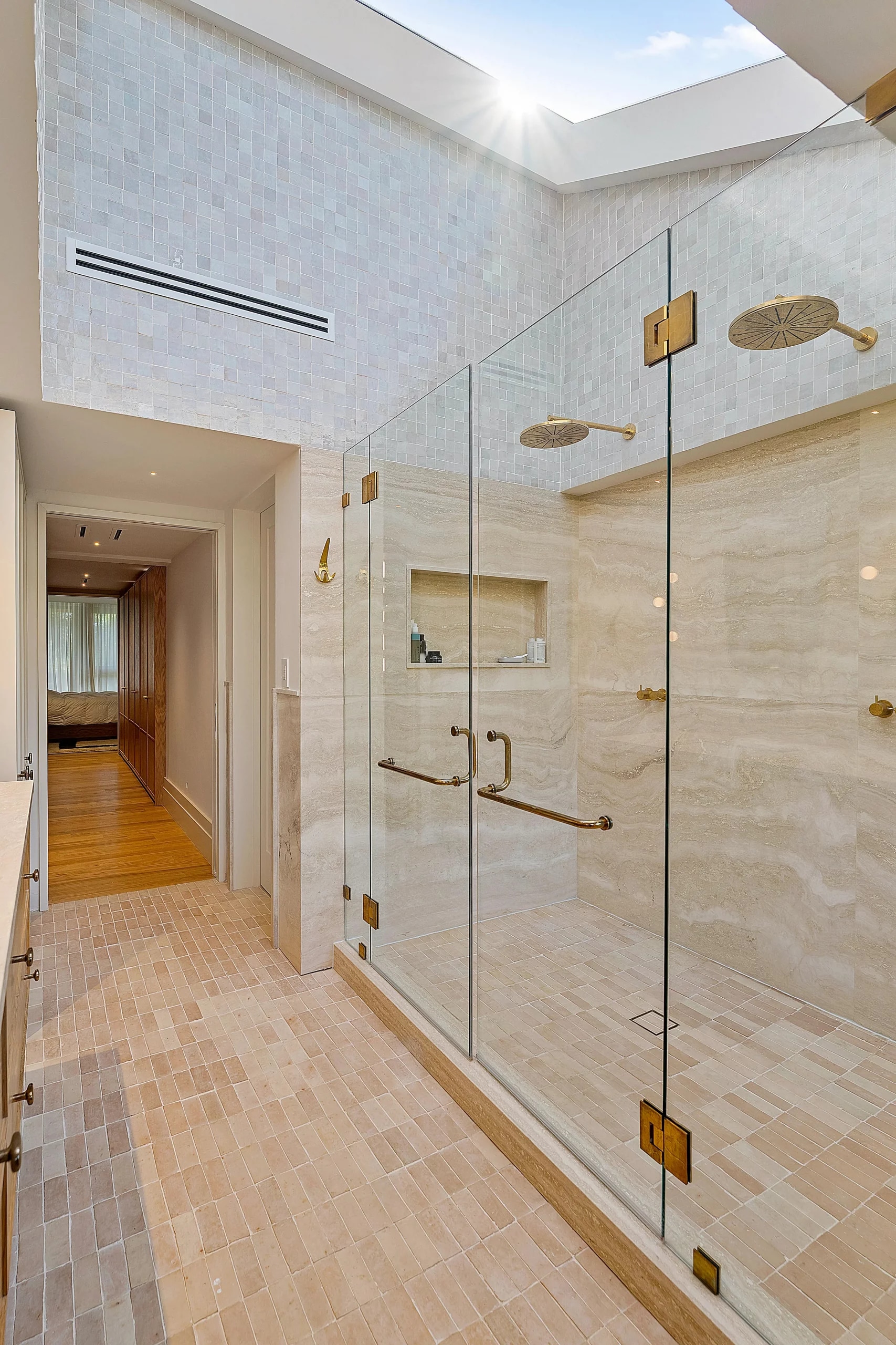 Tall shower enclosure with gold-toned hinges at Abitare