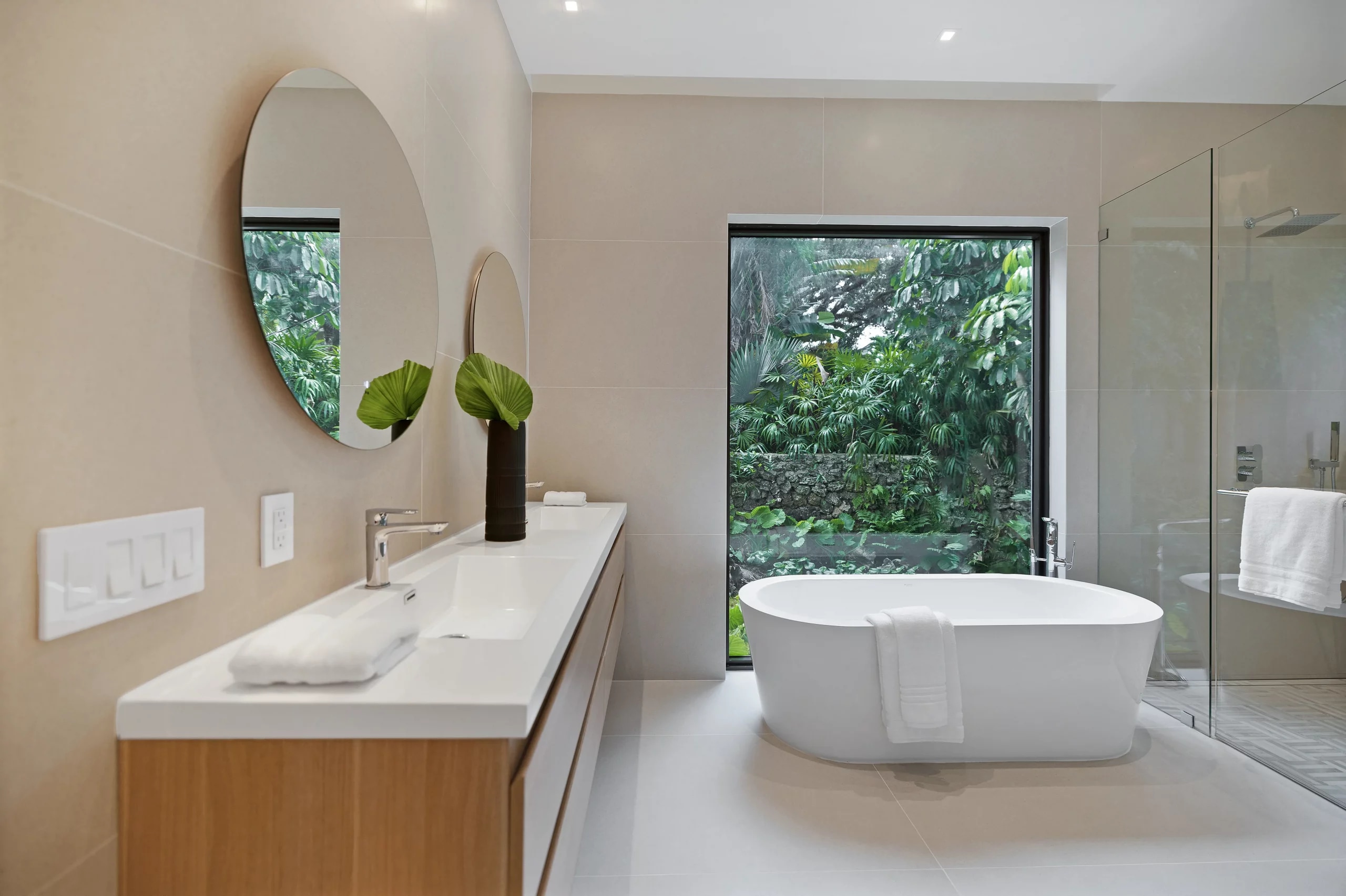 Round mirrors and shower glass in the primary bathroom at Opechee